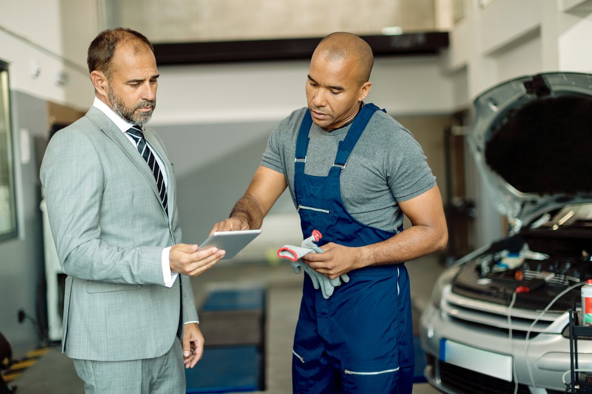 Mechanic and service manager reviewing car service report at Torque Experts Madhapur